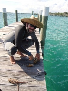 Captain David Ryan shows off snorkel-caught lobsters on Spanish Cay, Bahamas